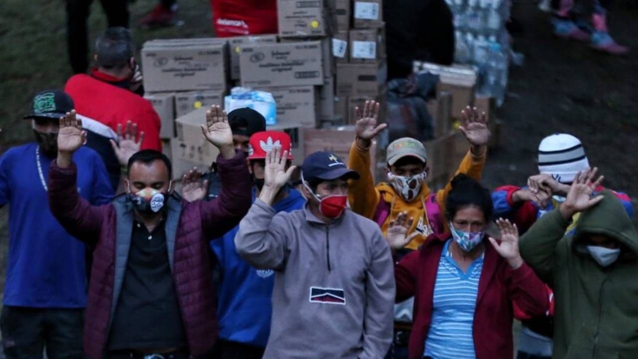 Población migrante en Colombia levantando las manos mientras se encuentra reunida en un parque. Población migrante en Colombia levantando las manos mientras se encuentra reunida en un parque.